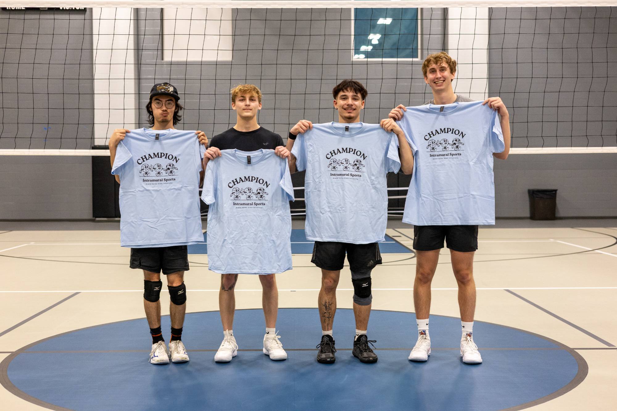 Grand valley students posing with championship t-shirt for winning the blue volleyball bracket.